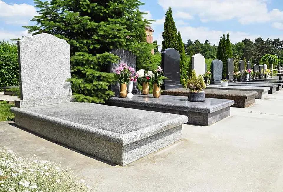 Tombes en granit parfaitement entretenues dans un cimetière.