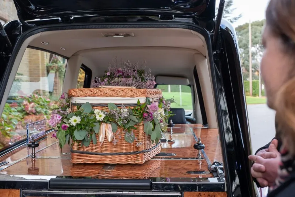Cercueil écologique en osier fleuri préparé pour le transport funéraire.