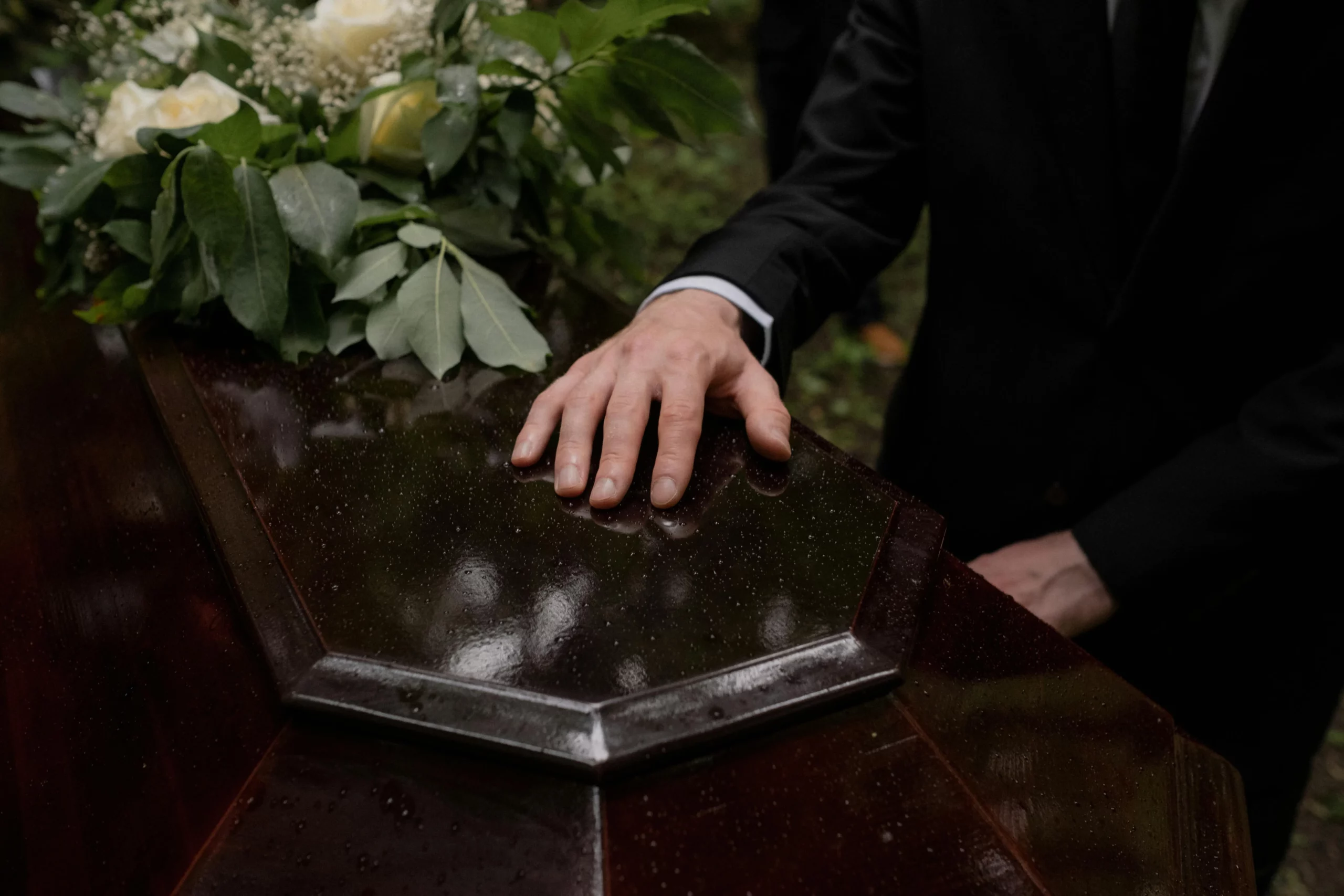 Hommage et recueillement d'un proche devant le cercueil verni